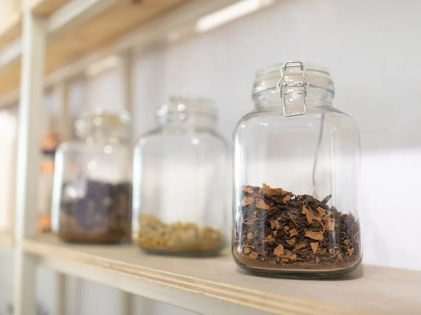 Bocaux de plantes séchées sur une étagère de cuisine en bois
